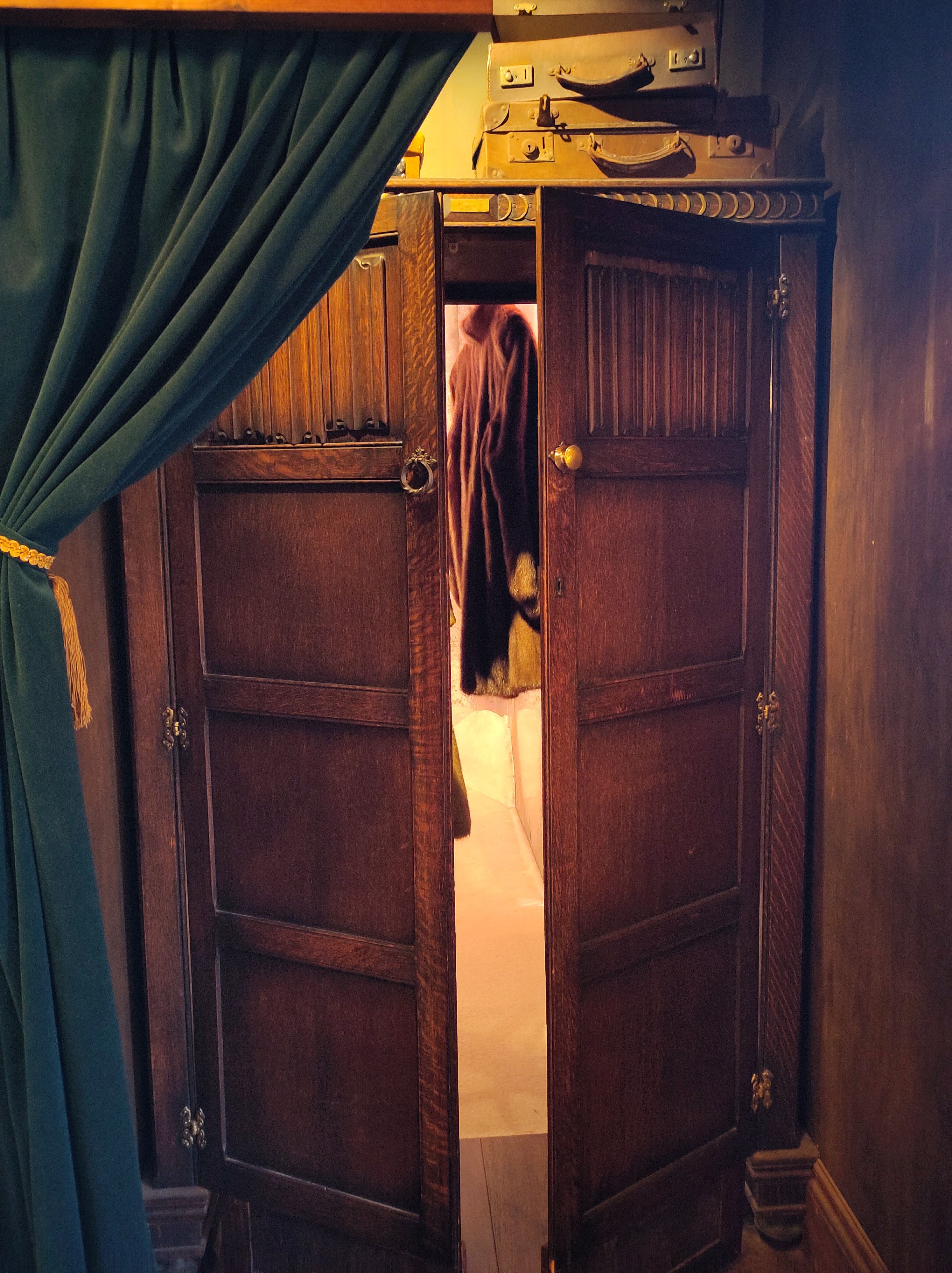A wooden wardrobe with partially open doors.