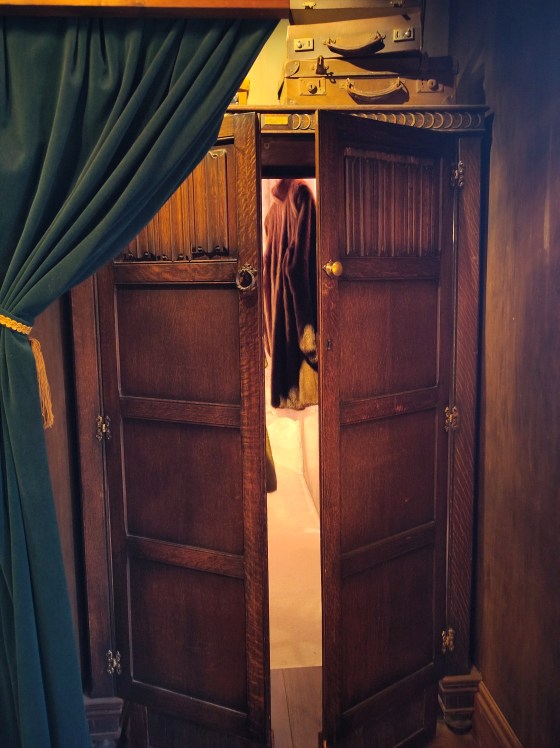 A wooden wardrobe with partially open doors.